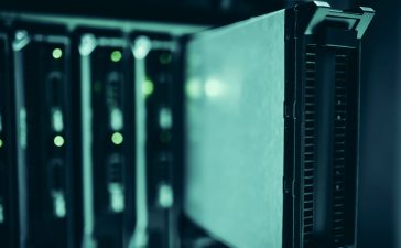 Racks de servidores em um moderno data center, iluminados em tons de azul.