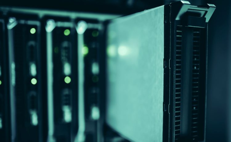 Racks de servidores em um moderno data center, iluminados em tons de azul.