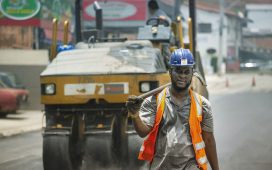 Trabalhador usando capacete e equipamentos de segurança atua em uma obra viária urbana em Cotia, no Brasil
