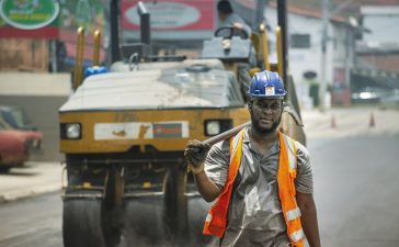 Trabalhador usando capacete e equipamentos de segurança atua em uma obra viária urbana em Cotia, no Brasil
