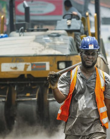 Trabalhador usando capacete e equipamentos de segurança atua em uma obra viária urbana em Cotia, no Brasil