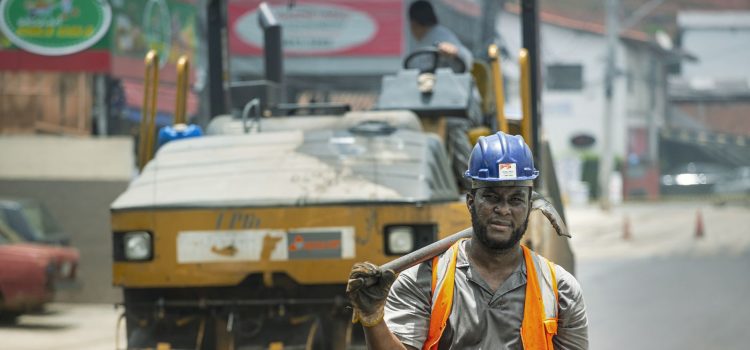 Trabalhador usando capacete e equipamentos de segurança atua em uma obra viária urbana em Cotia, no Brasil