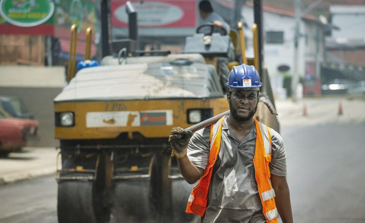 Trabalhador usando capacete e equipamentos de segurança atua em uma obra viária urbana em Cotia, no Brasil