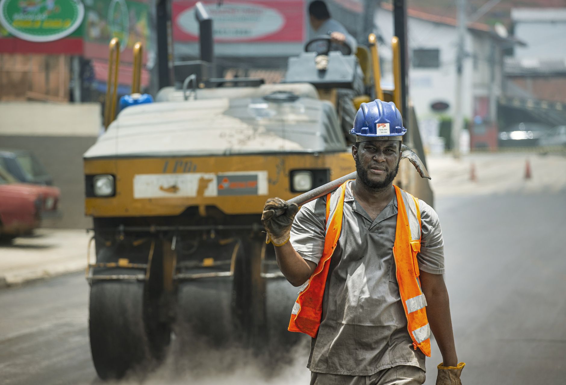 Trabalhador usando capacete e equipamentos de segurança atua em uma obra viária urbana em Cotia, no Brasil