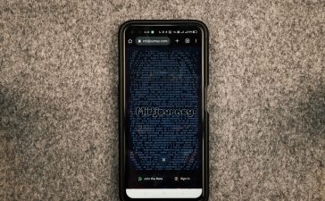 Smartphone exibindo o site Midjourney, plataforma de geração de imagens por inteligência artificial, sobre uma superfície cinza