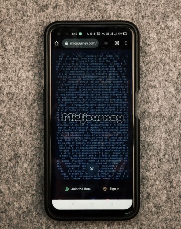 Smartphone exibindo o site Midjourney, plataforma de geração de imagens por inteligência artificial, sobre uma superfície cinza