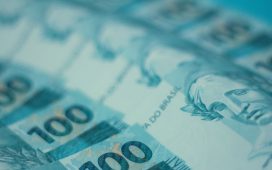 Cédulas de 100 reais brasileiras dispostas em detalhe.