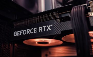 Placa de vídeo GeForce RTX instalada dentro de um computador, com iluminação alaranjada.