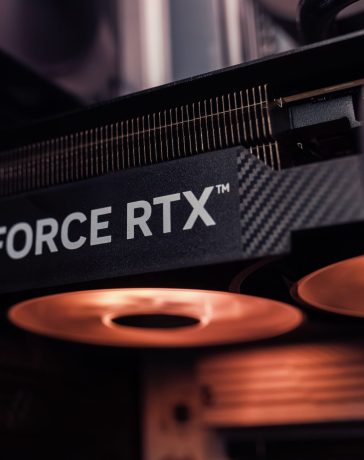 Placa de vídeo GeForce RTX instalada dentro de um computador, com iluminação alaranjada.